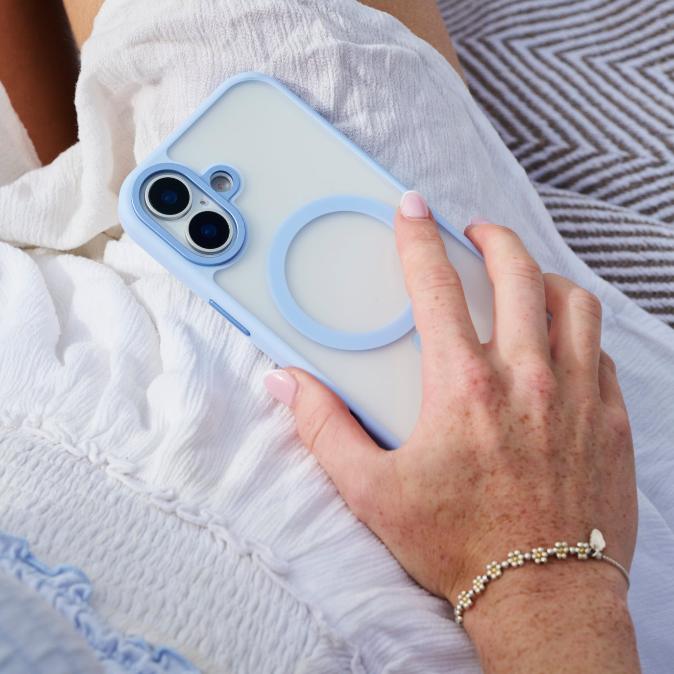 lady holding iPhone 17 with a light blue protective case.
